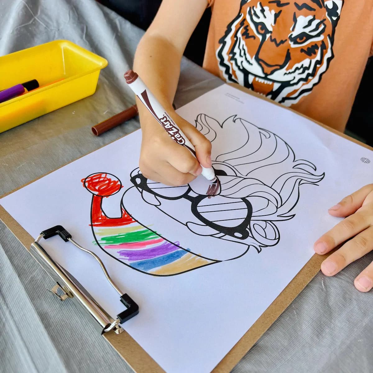 Child carefully colouring a detailed animal illustration at an Event Sitters activity station